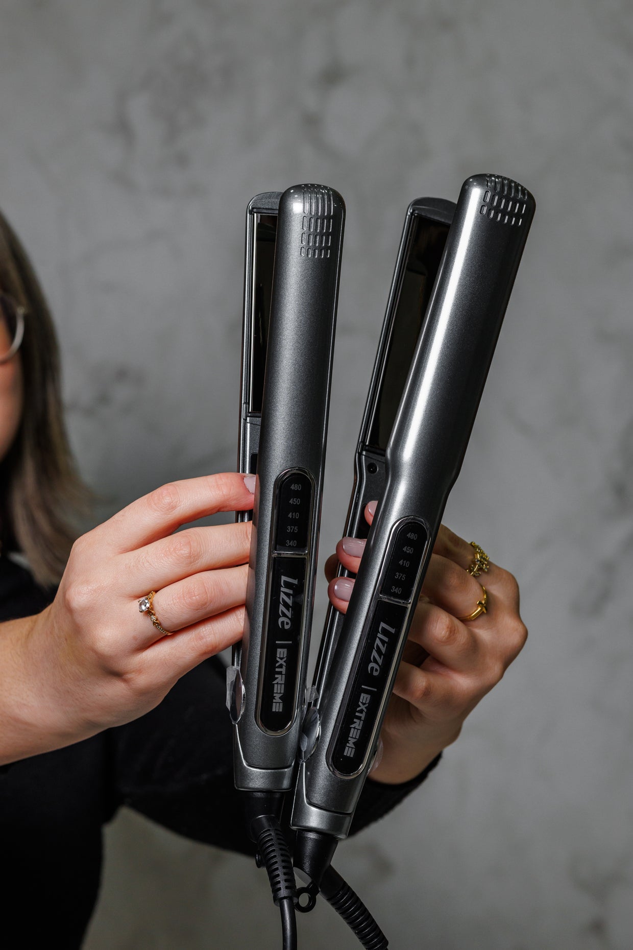 Une personne tenant deux lisseurs Luxe côte à côte sur fond gris. Idéal pour le lissage brésilien. Meilleure source d'avis sur Enissati.