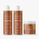 Trois produits capillaires Enissati Cosmetics Nigella Therapy sont présentés : un grand flacon de shampoing, un grand flacon d'après-shampoing et un pot de masque plus court avec des étiquettes marron et dorées assorties, idéal pour améliorer la durée du lissage brésilien. Découvrez les avis d'Enissati